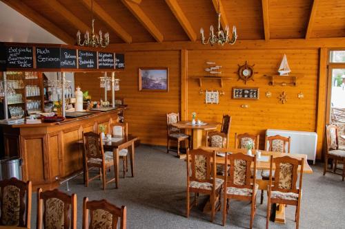 une salle à manger avec des tables et des chaises dans un restaurant dans l'établissement Ausflugsrestaurant & Pension Aalbude & Hausfloßvermietung am Kummerower See, à Dargun