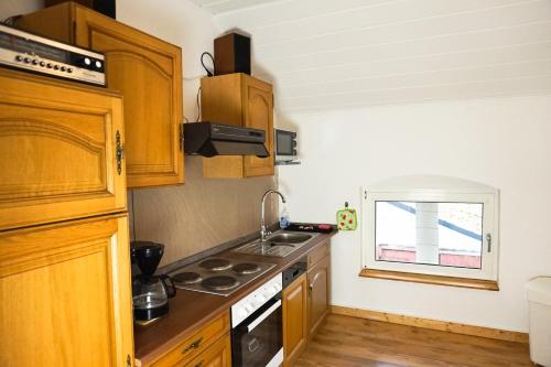 a kitchen with wooden cabinets and a stove top oven at Alte Mühle Kelbra - ehemalig ALBIG in Kelbra