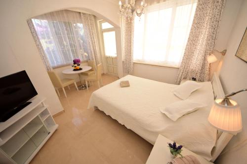 1 dormitorio con cama, mesa y TV en Apartments Cale, en Orebić