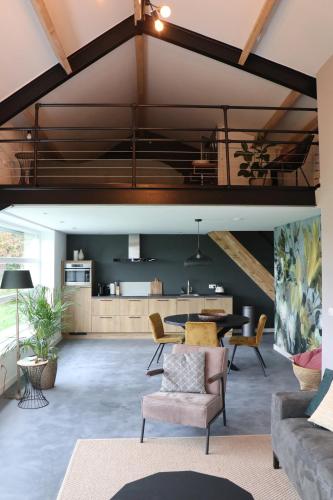 an open living room with a table and chairs at Met de Kippen op Stok - Vakantiehuisjes in Baexem