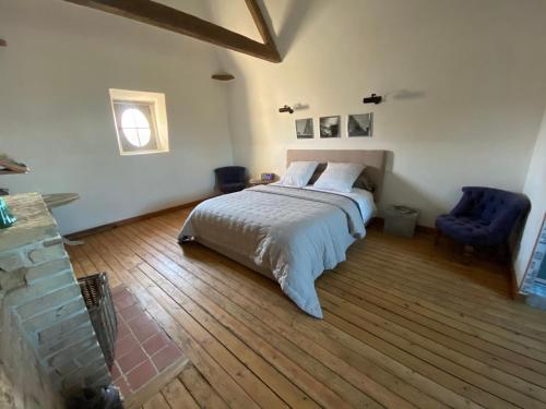 1 dormitorio con 1 cama y 1 silla azul en B&B - Entre terre et mer, en Frettecuisse