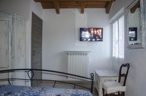 a bedroom with a bed and a tv on the wall at AnMa Cottages The Secret Garden in Pianello Del Lario