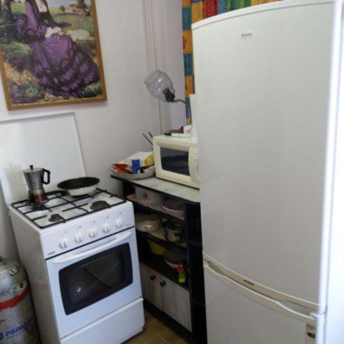 a kitchen with a white stove and a microwave at Bundik Vendégház in Berettyóújfalu