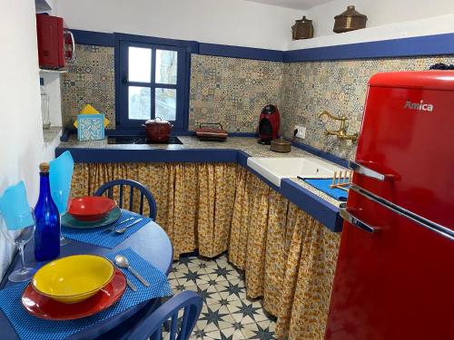a kitchen with a red refrigerator and a table at El Escondite de Martina, Áticos Románticos in Setenil