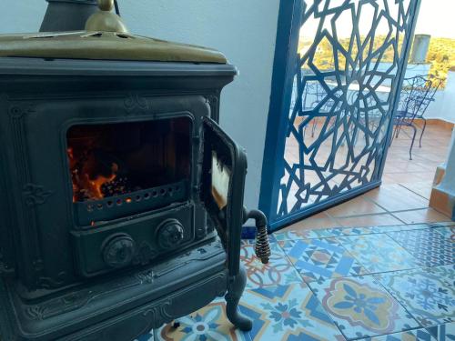 a green stove sitting in a living room with a door at El Escondite de Martina, Áticos Románticos in Setenil