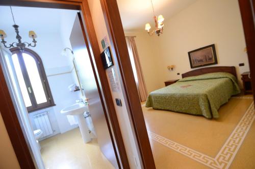 a bedroom with a bed and a door leading to a bathroom at Poggio Degli Olivi in Monsummano