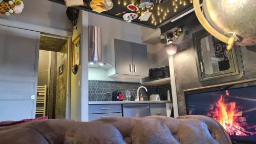 uma sala de estar com lareira numa cozinha em Studio renversant insolite em Sablé-sur-Sarthe