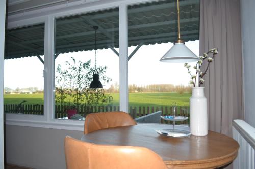a dining room with a table and a window at Bed & Breakfast Boszicht Leeuwarden in Leeuwarden