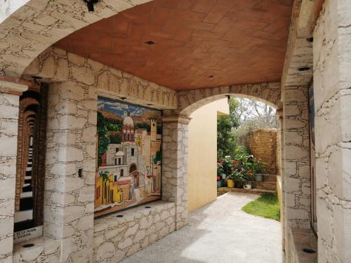 une arche dans une maison avec une peinture sur le mur dans l'établissement Posada Casa del Minero, à Mineral de Pozos