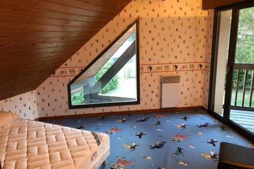 um quarto com uma cama e duas janelas num camarote em LUCHON Chalet 16 Couchage em Montauban-de-Luchon