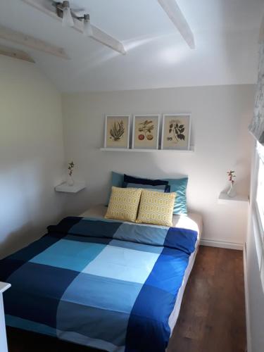 Ostrowo domek في أوستروفو: غرفة نوم صغيرة بسرير ازرق وبيض