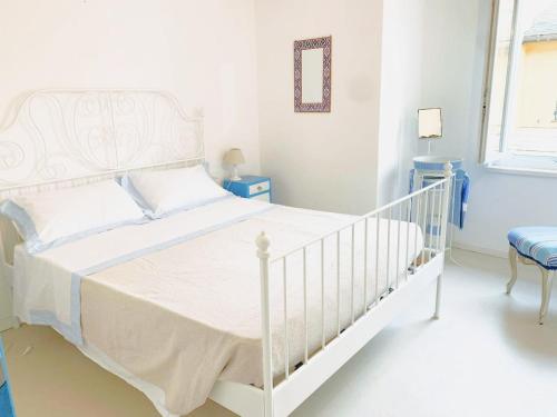una camera bianca con un letto bianco e una sedia di seahousevarazze a Varazze