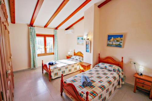 a bedroom with two beds and a window at Finca Palacios - comfortable holiday accommodation in Benissa in Benissa