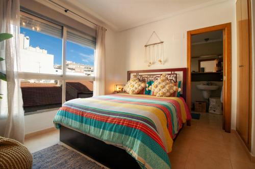 a bedroom with a bed and a large window at El apartamento de Maria Jose in Torrevieja