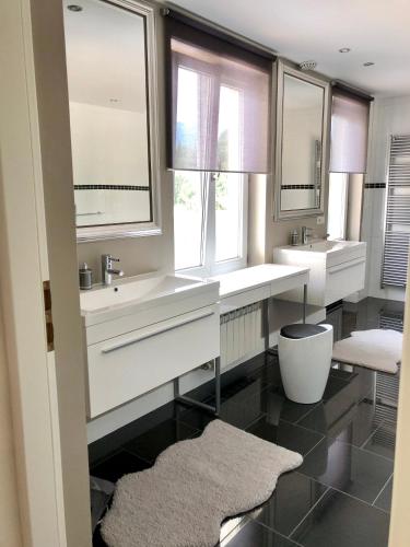 a bathroom with two sinks and two windows at Villa Bergzicht in Vulcan
