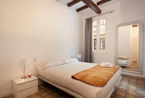 a white bedroom with a large bed and a window at Barnapartments Basic Gracia in Barcelona