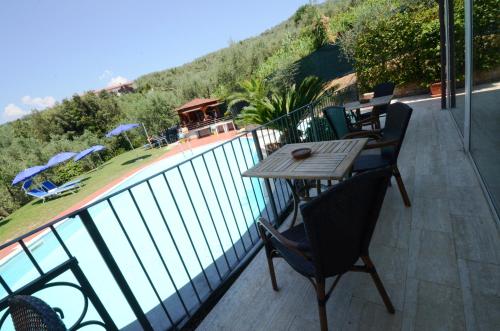 a balcony with a table and chairs and a pool at Poggio Degli Olivi in Monsummano