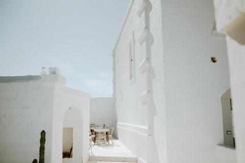 a white room with a table and a white wall at Masseria D'Erchia in Monopoli