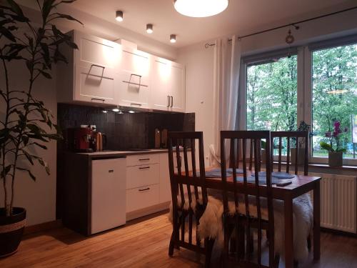 cocina con mesa y 2 sillas y comedor en Apartamenty 33, en Zakopane