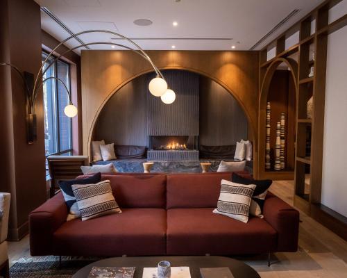 a living room with a couch and a fireplace at Kimpton Saint George Hotel, an IHG Hotel in Toronto