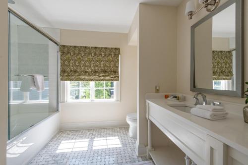 W łazience znajduje się umywalka, toaleta i lustro. w obiekcie The Greystone Inn w mieście Lake Toxaway