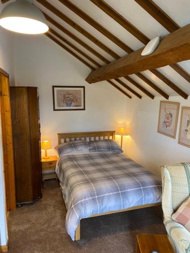 a bedroom with a bed and a couch at Bank Farm Cottages in Nantwich