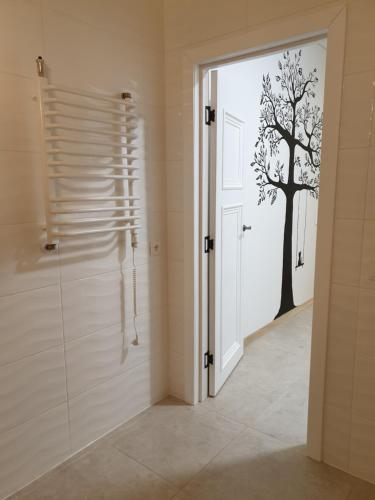La salle de bains est pourvue d'une porte avec un pochoir d'arbre sur le mur. dans l'établissement Skuodo IIB, à Kaunas