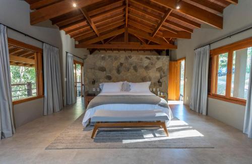 um quarto com uma cama grande num quarto com janelas em Canto do Irere - Boutique Hotel em Atibaia