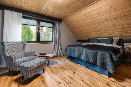 a bedroom with a bed and a chair and a window at Międzybrodzie Bialskie Apartamenty Nowy Świat in Międzybrodzie Bialskie