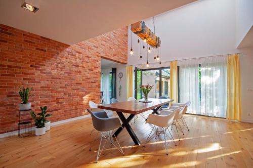 ein Esszimmer mit einer Ziegelwand, einem Tisch und Stühlen in der Unterkunft Wiselka Holiday House-1,2km to the beach; 5 bedrooms, 3 bahrooms; fire place. Private sauna! in Wisełka
