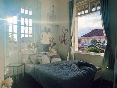 a bedroom with a bed and a window at The Balcony BnB in Da Lat