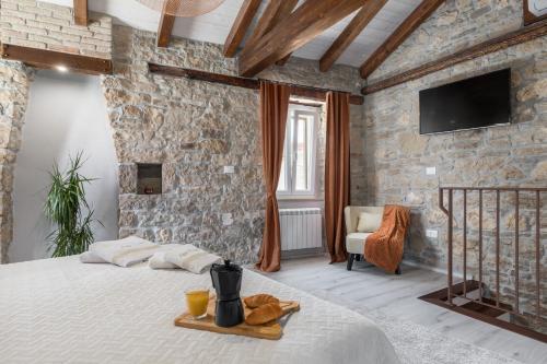 a bedroom with a large bed in a stone wall at Apartman Pisino**** 70m2, 2+2 in Pazin