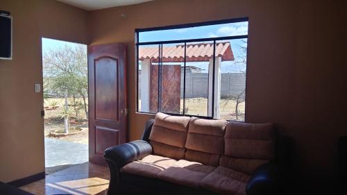 a living room with a couch in front of a window at Cabana con Vista al Mar in La Bocana