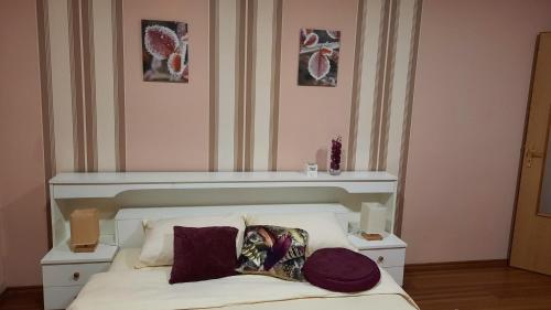 a bedroom with a bed with a white headboard and pillows at Apartmani RALE rooms in Sarajevo