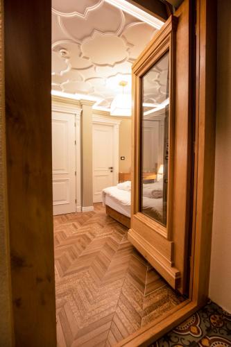 a mirror in a room with a bed and a bedroom at Vila EKREM in Korçë