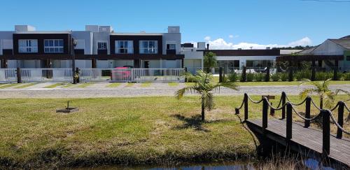 a house with a palm tree next to a bridge at Atlantida Park Residence in Xangri-lá