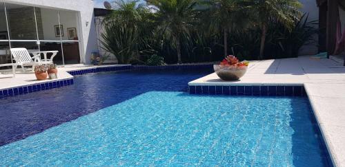 uma grande piscina com água azul numa casa em Atlantida Park Residence em Xangri-lá