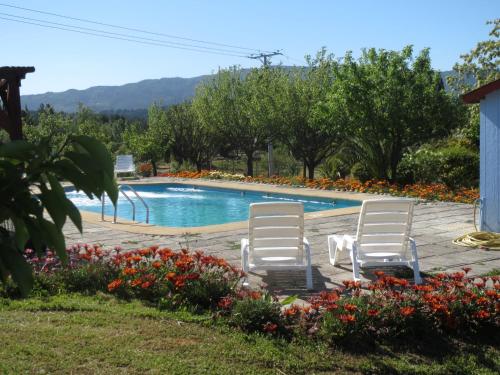 dos sillas blancas sentadas junto a una piscina en Cabañas Club Mediterraneo, en Quillón