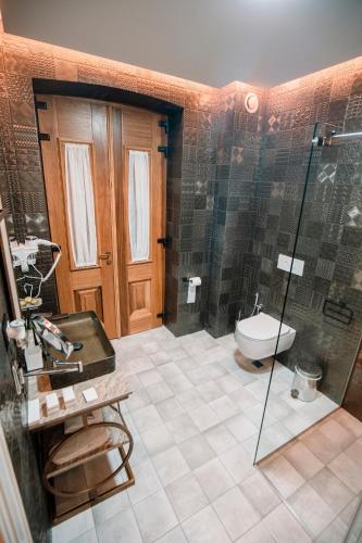 a bathroom with a shower and a toilet and a sink at Vila EKREM in Korçë