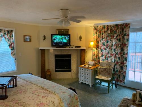 a bedroom with a bed and a tv on a fireplace at Emerald Necklace Inn Bed and Breakfast in Lakewood