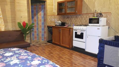 eine Küche mit einem weißen Herd und einer Mikrowelle in der Unterkunft Cottage Mango in Castara