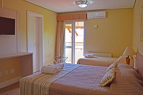 a hotel room with two beds and a window at Sky Ville Hotel Canela in Canela