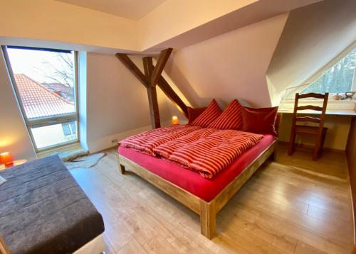 Schlafzimmer mit einem Bett mit einer roten Bettdecke in der Unterkunft Leipziger Logis in Leipzig