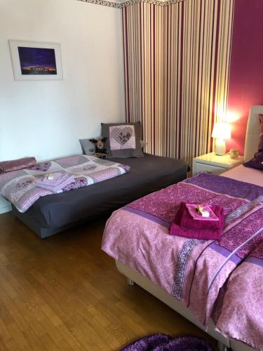 2 camas en una habitación con sábanas moradas en Haus Zissi en Burg-Reuland