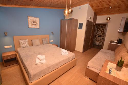 a bedroom with a large bed and a couch at Studios Sotiria in Limenas
