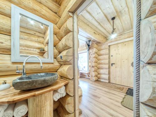 a bathroom with a stone sink in a log cabin at Zagroda Krowiarki Chochołów in Chochołów
