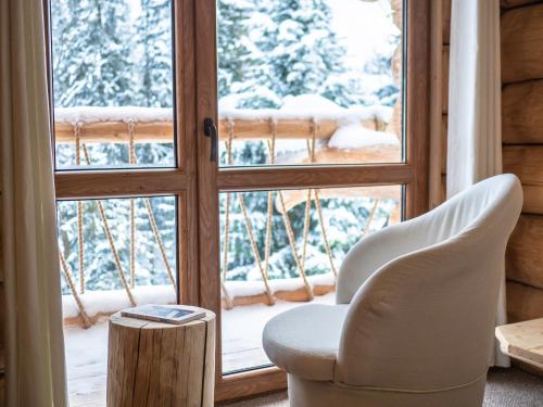a room with a chair and a window with snow at Zagroda Krowiarki Chochołów in Chochołów