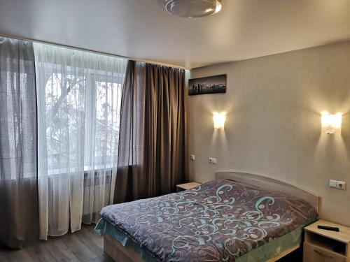 um quarto com uma cama e uma grande janela em НОВАЯ КВАРТИРА на пр. Соборном возле ЗНУ em Zaporozhye
