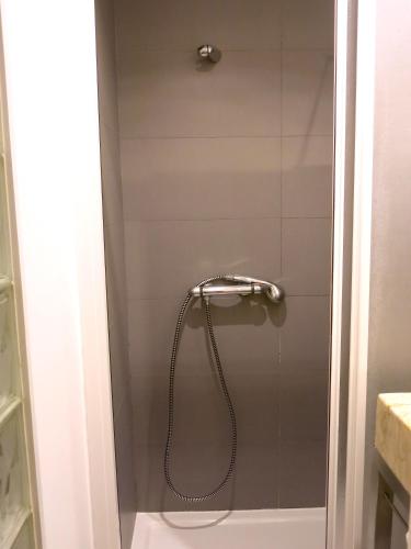 a shower with a shower head in a bathroom at Cozy Studio in Mouraria with AC in Lisbon