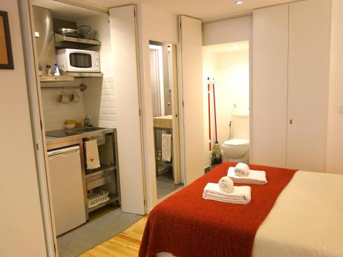 a small room with a bed and a microwave at Cozy Studio in Mouraria with AC in Lisbon